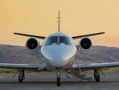 Front view of a private jet on ramp at sunset