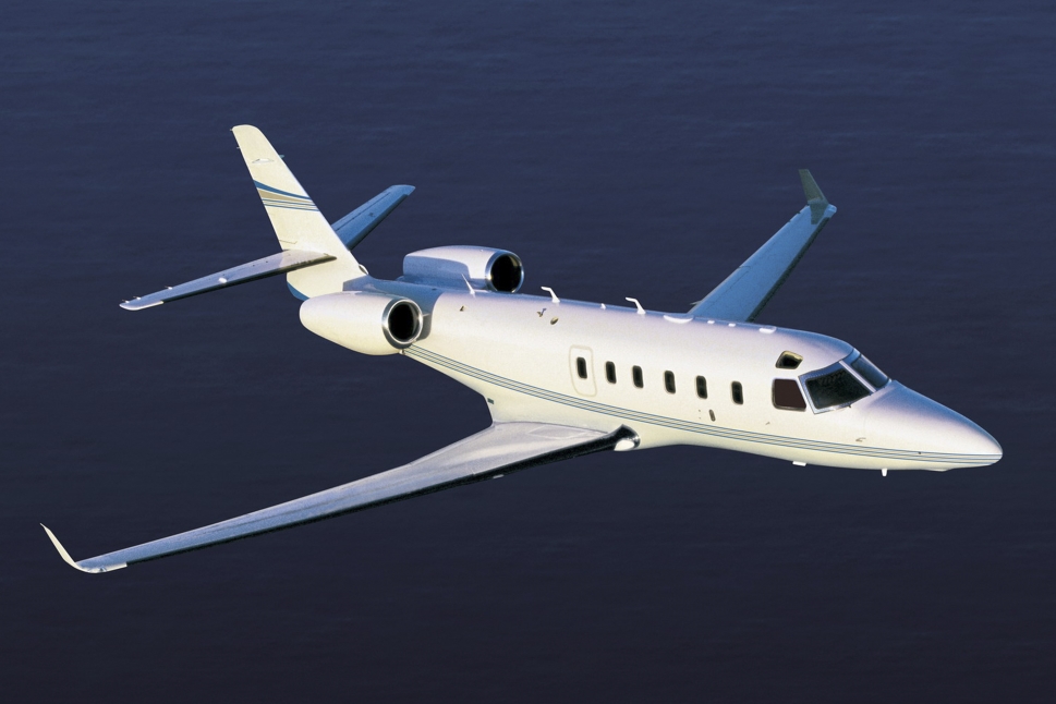 A Gulfstream G100 mid-size private jet flying across the ocean