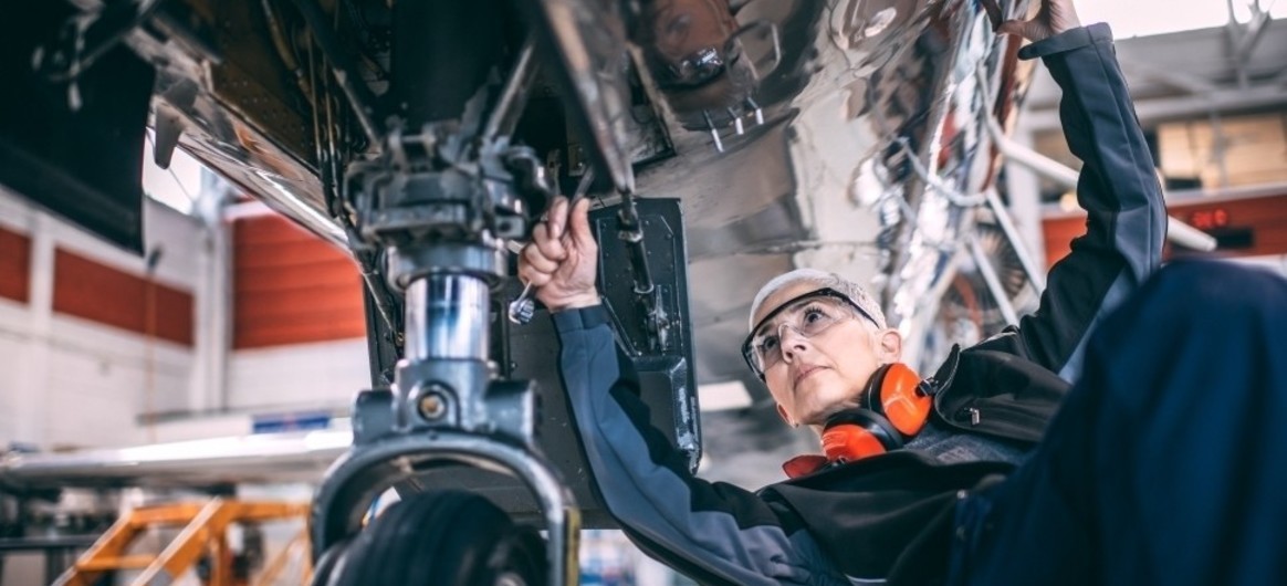 Aircraft mechanic works on business jet's wheels and brakes